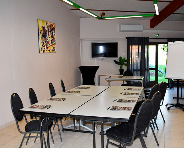 Salle Fleurette du Relais du Moulin Neuf en configuration rectangle, avec TV murale, paperboard et accès extérieur
