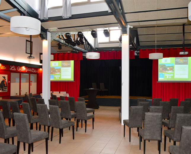 Salle Spectacle du Relais du Moulin Neuf en configuration conférence avec scène et double projection