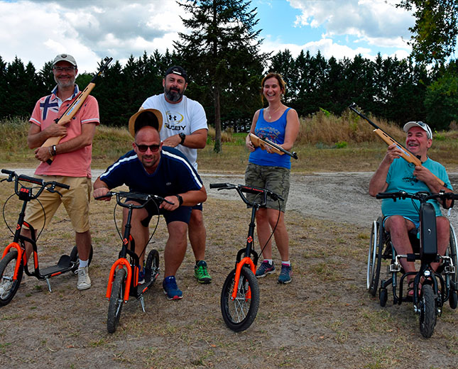 Équipe en team building « biathlon gascon » avec trottinettes et carabines laser, activité accessible au Relais du Moulin Neuf